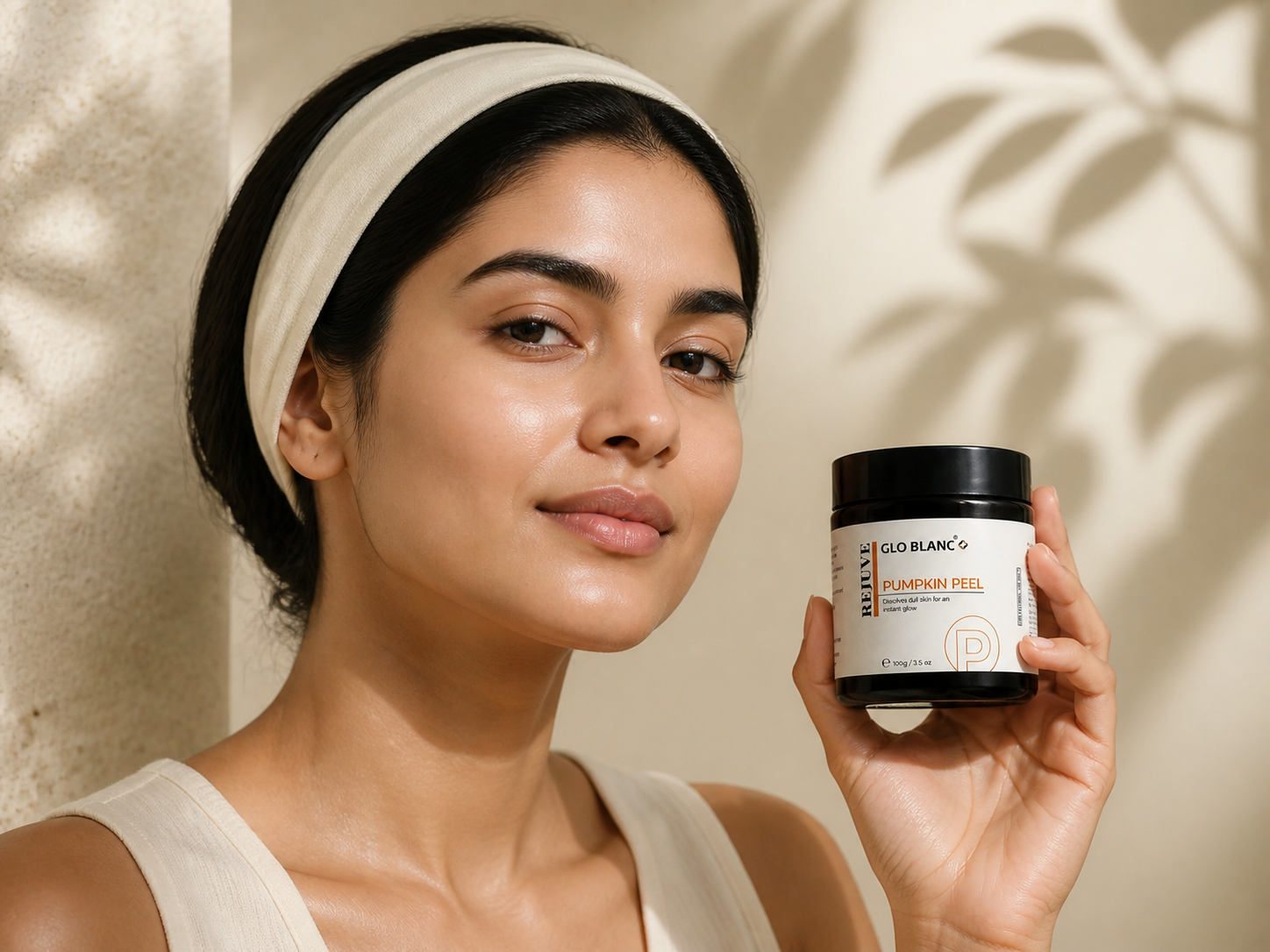 Indian skincare model holding a Pumpkin Peel jar